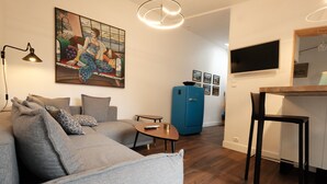 Un salon moderne avec un canapé gris, une petite table basse et un meuble bleu.