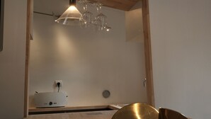 Une chambre moderne avec une tête de lit en bois, une table de chevet et un luminaire suspendu.