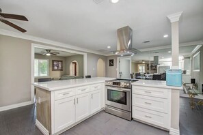 A modern kitchen with white cabinetry, a stainless steel range, and a built-in oven.