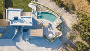 Une maison moderne dotée d’une piscine, d’un espace salon extérieur et d’un jardin aménagé.