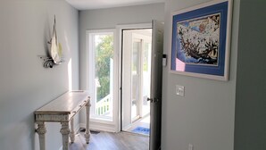 A hallway with a white table, a sailboat decoration, and a framed map on the wall. - Waterfront Paradise on the Eastern Shore of Chesapeake Bay  (Rock Hall)