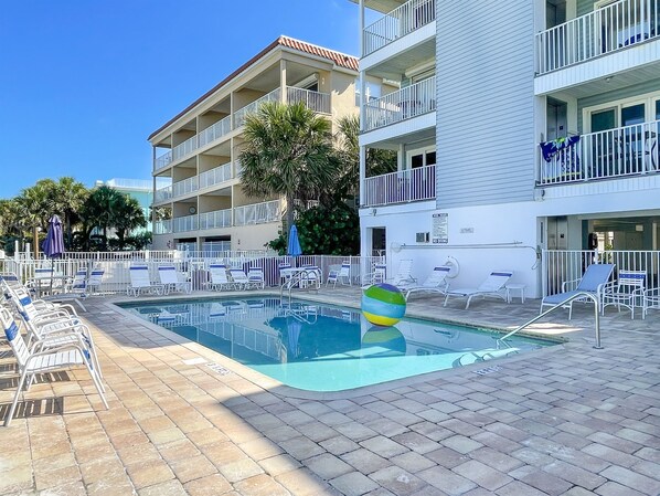 A pool area with lounge chairs and a large inflatable ball. - Oceanfront Oasis with Private Elevator (Indian Rocks Beach)