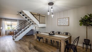 A spacious dining area with a wooden table and chairs, a staircase, and a large potted plant. - 4BR Townhome | Pool | Old Town Scottsdale (Scottsdale)