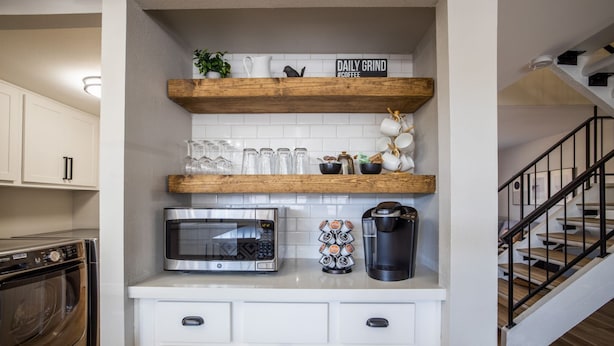 A kitchen with white cabinets, a microwave, a Keurig coffee maker, and a shelf with mugs and glasses. - 4BR Townhome | Pool | Old Town Scottsdale (Scottsdale)