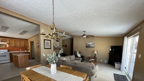 Amplia sala de estar con una mesa de comedor, sofá y cocina al fondo.