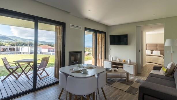 A modern hotel room with a balcony, a dining area, a TV, and a bedroom. - Vila Vicente-Wellness, Fantastic Views and Parking (S. Vicente Ferreira)
