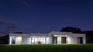 A modern house with a flat roof, large windows, and a well-maintained lawn. - Vila Vicente-Wellness, Fantastic Views and Parking (S. Vicente Ferreira)