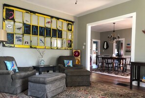 Cozy living space with comfortable seating and a decorative wall panel featuring a family theme.