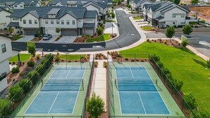 A residential area with modern houses, a tennis court, and a road. - O-65| Poolhouse at Ocotillo Springs * Private Pool (Santa Clara)