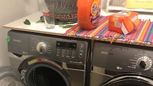 A Samsung front-loading washer and dryer set with a colorful, patterned cloth on top.