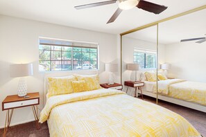 Relax in a serene space with a large bed, bedside tables, and a ceiling fan for comfort.