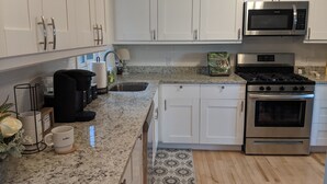 A modern kitchen with white cabinets, a stainless steel microwave, an oven, and a granite countertop. - Big Views, Hot Tub, Dog Friendly, 5min to BR (Blowing Rock)