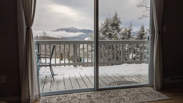 A room with a sliding glass door leading to a deck with a wooden railing. - Big Views, Hot Tub, Dog Friendly, 5min to BR (Blowing Rock)