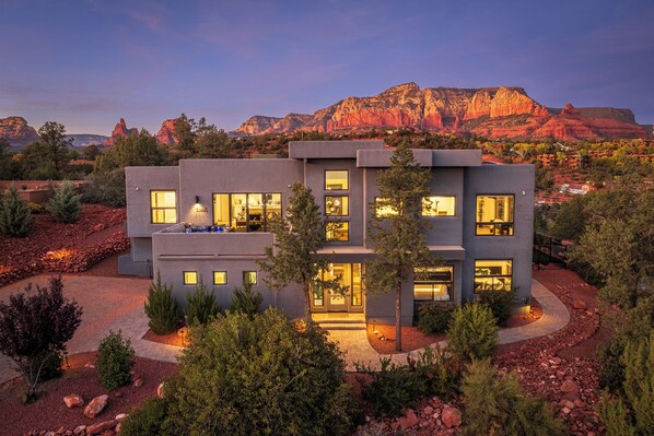 A modern two-story house with large windows and a well-maintained garden. - Sedona Dream Estate - 5BR Huge Pool/Spa/Firepit/Golf/Sauna (Sedona)