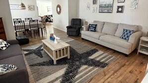 Un salon comprenant un canapé, une table basse et un coin repas avec des chaises et une table.
