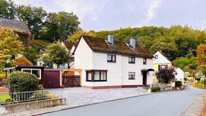 A two-story house with a front porch, a garage, and a driveway. - Casa Siepelunga (Villmar)