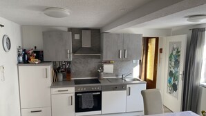 A modern kitchen with white cabinets, a built-in oven, and a sink. - Casa Siepelunga (Villmar)
