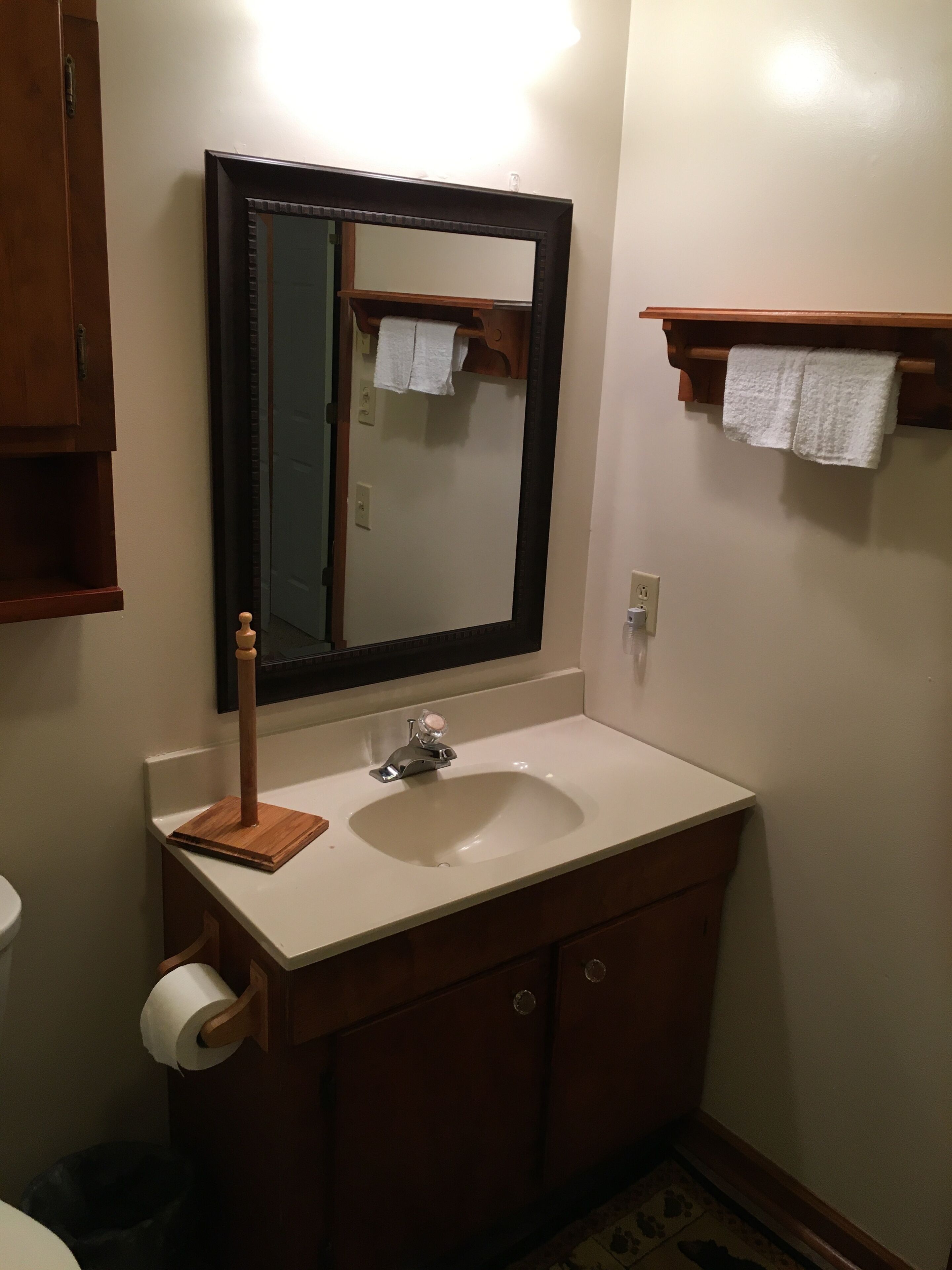 A bathroom with a sink, mirror, towel rack, and toilet.