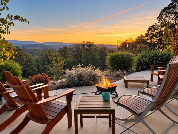 A patio with outdoor furniture, a fire pit, and a view of the landscape.
