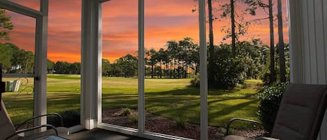 Una serra con vista su un campo da golf al tramonto.