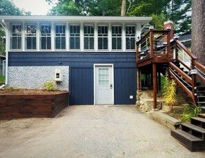 Two-story building with a wooden staircase and second-floor deck area.