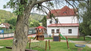 Un parque infantil con columpios, un tobogán y una estructura para escalar.
