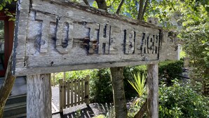 A wooden sign with the text "TO THE BLACK" mounted on a post. - Vintage-inspired cottage in Seabrook, sleeps 7 (Pacific Beach)