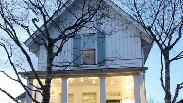 A two-story house with a porch and a staircase leading to the entrance. - Vintage-inspired cottage in Seabrook, sleeps 7 (Pacific Beach)