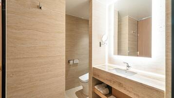 A modern bathroom with a marble vanity, a large mirror, and a toilet.