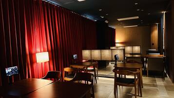 A hotel room with a red curtain, wooden furniture, and a modern design.