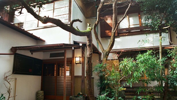 A traditional Japanese courtyard with a wooden gate, stone lantern, and various plants. - Hakonowa Hot spring inn (Hakone)