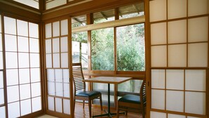 A traditional Japanese room with tatami flooring, sliding doors, and a low table with two chairs. - Hakonowa Hot spring inn (Hakone)