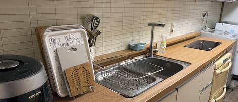 Une cuisine au design moderne, équipée d’un lave-vaisselle encastré, d’une machine à café et d’un appareil à pain.
