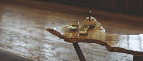 A wooden table with a glass top, a small bowl, and two glasses.