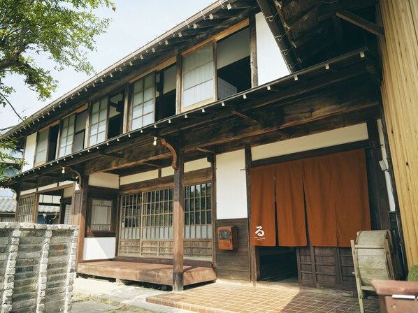 A traditional Japanese building with wooden beams, large sliding doors, and a tiled entrance.