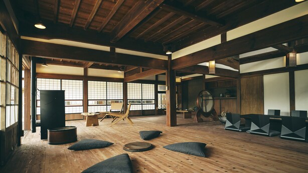 Quarto em estilo japonês tradicional, com tatames, vigas de madeira e painéis shoji.