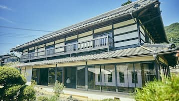 A traditional Japanese building with a tiled roof, wooden beams, and a balcony.