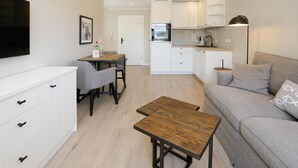 A modern apartment with a dining area, kitchen, and living room.