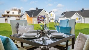 Une table à manger dressée pour quatre personnes, avec vue sur un quartier résidentiel.