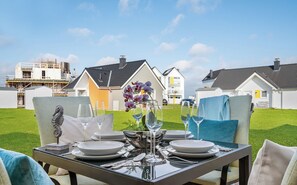 A dining table set for four with a view of a residential area.