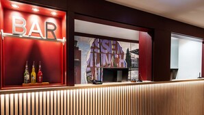 A bar area with a wooden reception desk, a 'BAR' sign, and a 'SUSHI' sign. - B&B Hotel München-Messe (Aschheim)