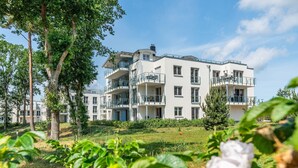 A multi-story residential building with balconies, surrounded by greenery and trees. - Apartment Kiefernblick - Haffresidenz (4a.7) - 4a.7 (Zirchow)