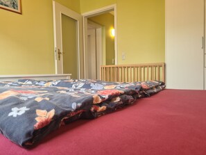 Ein Schlafzimmer mit einem Bett, einer Tür und einer Wandleuchte.