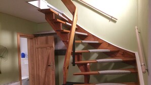 Una escalera de madera con barandilla y peldaños alfombrados.
