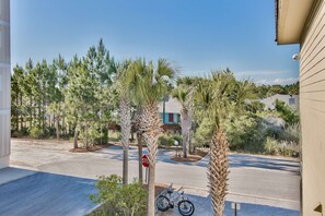 A residential street with palm trees, a bicycle, and a 'No Parking' sign.