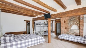 A room with two beds, a brick wall, and exposed wooden beams. - Crazy Villa Luigny (28) - Heated pool - City Stade - 1h20 Paris - 30P (Luigny)