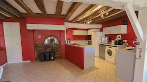 A kitchen with red walls, a white door, and a tiled floor. - Crazy Villa Luigny (28) - Heated pool - City Stade - 1h20 Paris - 30P (Luigny)