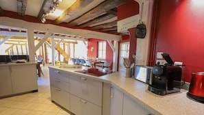 A kitchen with a large island, a coffee machine, and a red wall. - Crazy Villa Luigny (28) - Heated pool - City Stade - 1h20 Paris - 30P (Luigny)