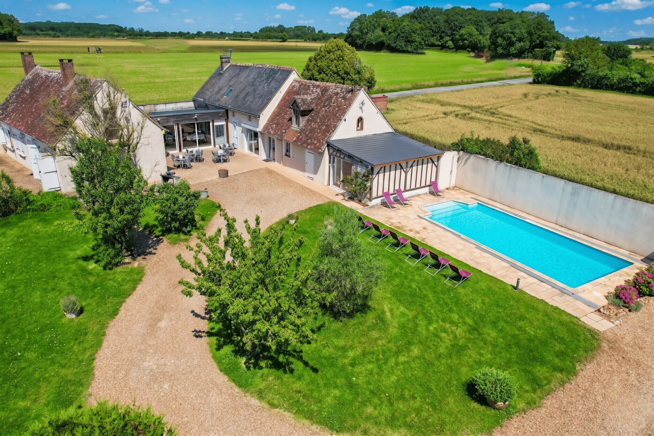 Ein Wohnhaus mit Schwimmbad, Sitzgelegenheit im Freien und einem Garten.
