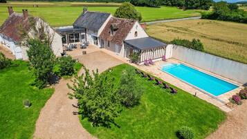 Ein Wohnhaus mit Schwimmbad, Sitzgelegenheit im Freien und einem Garten.